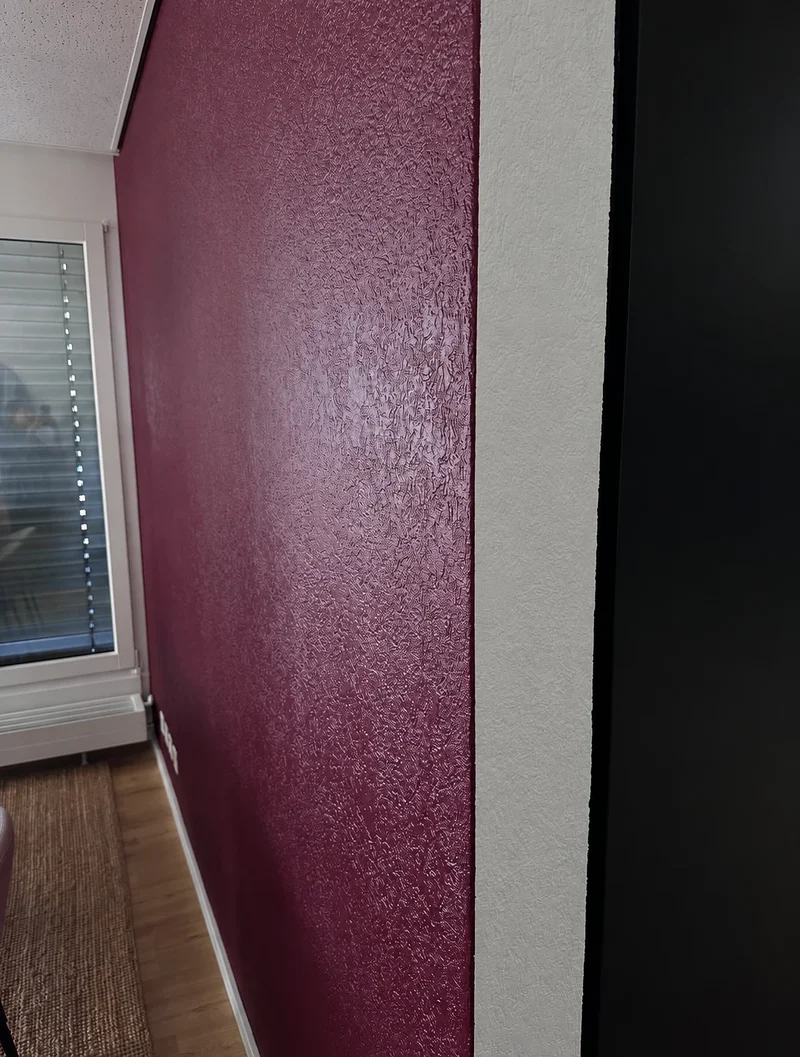 Détail de la texture bordeaux et de la jonction avec un mur blanc